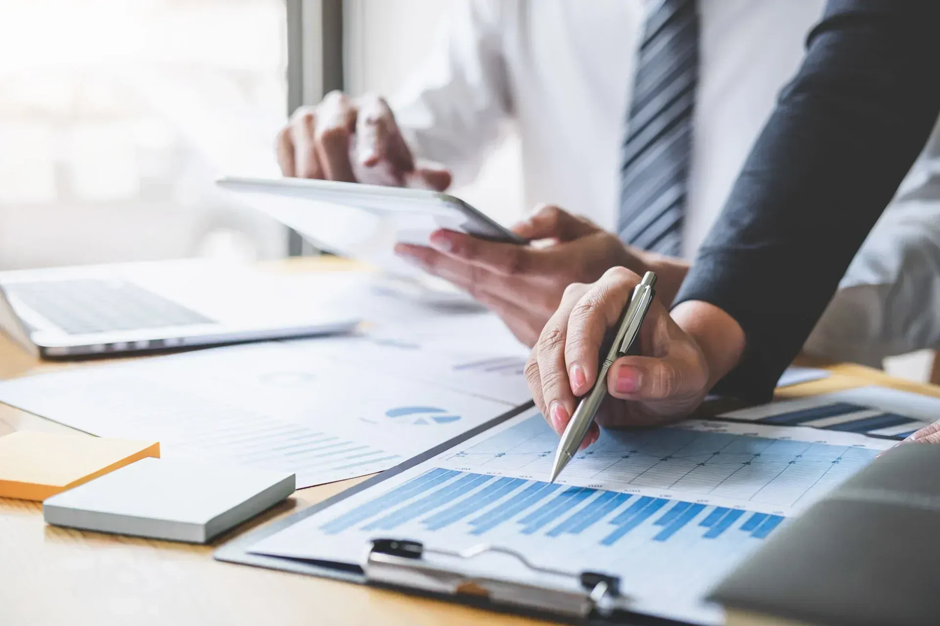 Owner and investor reporting documents with financial charts on a desk.