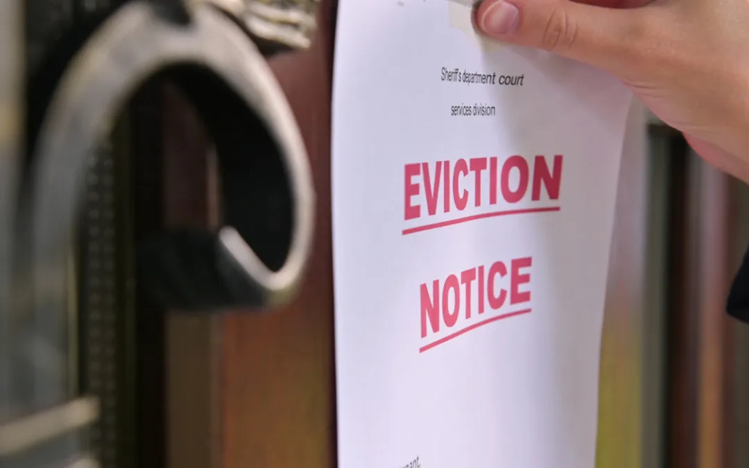 Person attaching an eviction notice to a door handle.